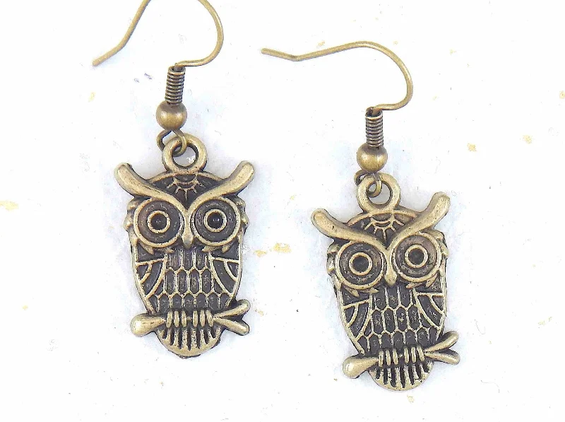 Short earrings with large brass owls sitting on a branch, brass hooks